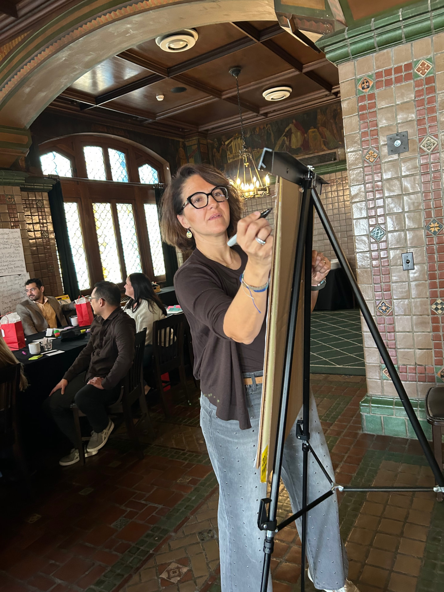 Irini facilitating a group exercise at a board