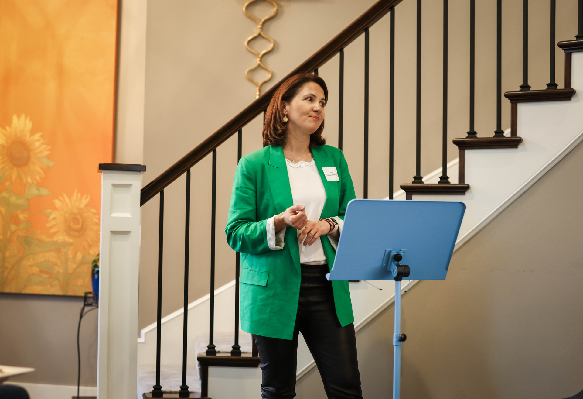 Irini speaking to a group in a green blazer